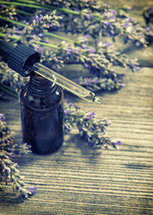 Obraz na płótnie Canvas Perfumed herbal oil essence and dreied lavender flowers. Vintage