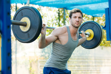 sports model exercising outside as part of healthy dumbbells