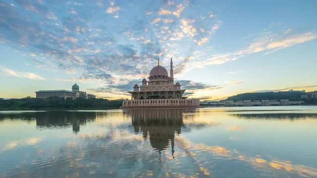 Time lapse 4k Footage of Beautiful Sunrise At Putra Mosque, Putrajaya With Zoom In Effect Towards The Mosque. Showing a moving and changing color clouds.