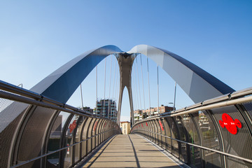 modern footbridge with supporting arches and steel bulkheads