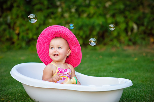 little girl in a red hat bathed in the bath