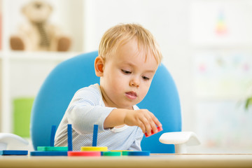 little kid boy playing with educational toys
