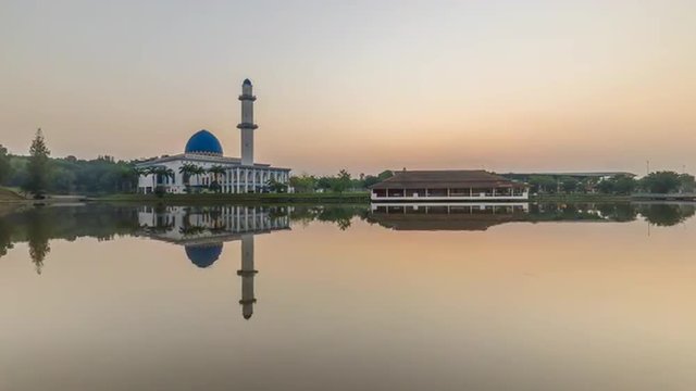 Time lapse 4k Footage of a beautiful Sunrise At UNITEN Mosque, Putrajaya With Zoom In Effect Towards The Mosque. Showing a rising sun from the horizon line.