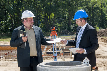 bauingenieure reichen sich unterlagen an