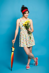 colorful portrait of young  funny  girl posing on blue wall 