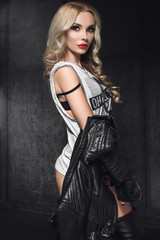 Fototapeta na wymiar Fashion woman model in leather jacket in studio on dark background