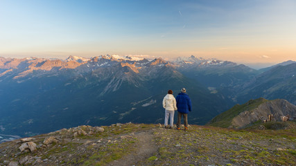 Fototapeta na wymiar Couple watching panorama high up in the Alps
