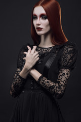 Portrait of gothic girl with black eyes in dark clothes