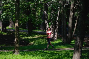 Fototapeta premium Beautiful woman runner running in city park