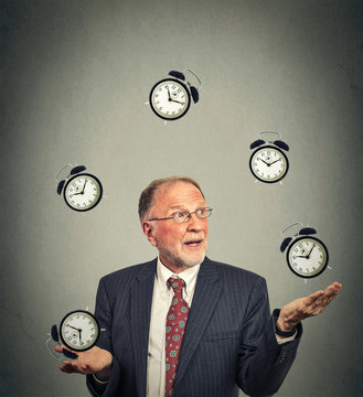 Business Man In Suit Juggling Multiple Alarm Clocks