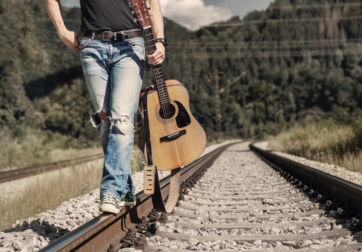 Close up image man legs in rippad denim walk on the railway