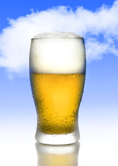 golden beer with frost bubbles in full tempting glass with white foam