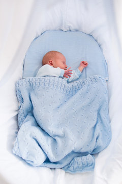 Newborn Baby Boy In White Bassinet