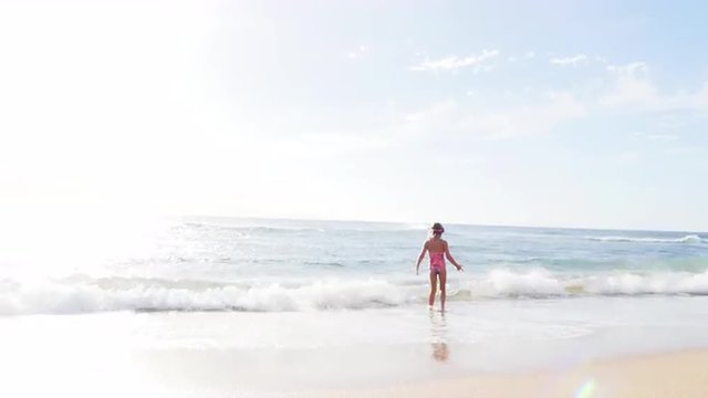 Cute blonde girl playing in the ocean