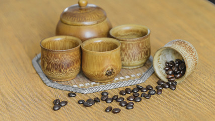 Soft focus image of coffee beans and coffee cups set on wooden b