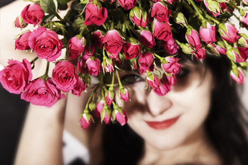 Obraz premium brunette woman with a bouquet of pink roses