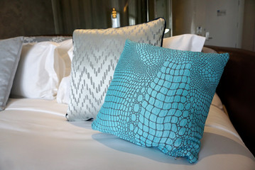 crocodile skin blue fabric cushion on the bed