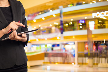 Woman using tablet in shopping mall.