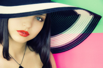 face of  young beautiful brunette in a summer hat