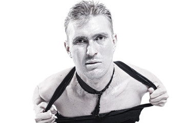 Young man tearing at his shirt