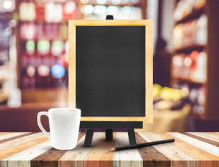 Blackboard menu with easel on wooden table with coffee cup and p