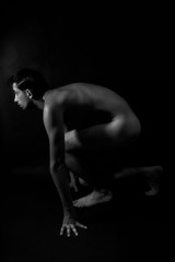 Fototapeta na wymiar Nude male athlete preparing for the start