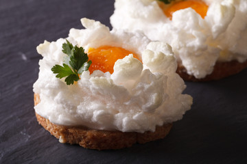 Eggs Orsini: baked whipped whites and yolk on toast. Horizontal closeup
