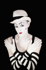 Ape mime in striped gloves and white hat on black background