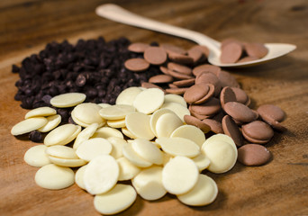 Chocolate morsels pile in spoon on wooden table