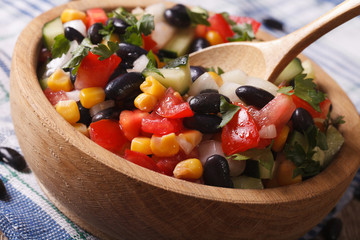 Mexican vegetable salad macro in a wooden plate. horizontal
