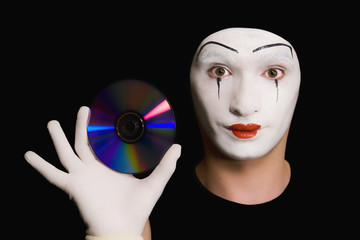 Portrait of  mime with cd on  black background