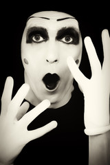 Portrait of the surprised mime in white gloves