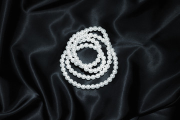 white pearl necklace on a black silk close up