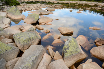 Fototapeta na wymiar Stones in lake in mountains.