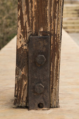 Rusty iron tie on a wooden beam