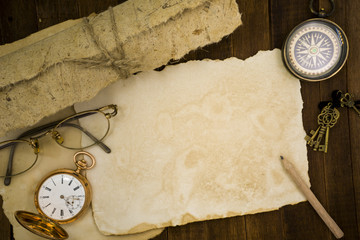 Fototapeta na wymiar Old paper, compass, pocket watch on wooden background