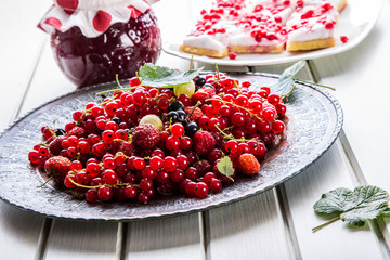 Red currant sponge cake. Plate with Assorted summer berries, raspberries, strawberries, cherries, currants, gooseberries 