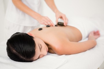 Fototapeta na wymiar Pretty woman receiving a hot stone massage