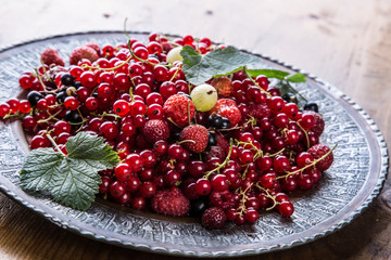 Red currant sponge cake. Plate with Assorted summer berries, raspberries, strawberries, cherries, currants, gooseberries 