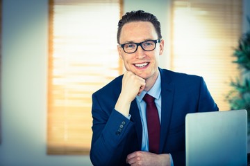 Happy businessman sitting at his desk