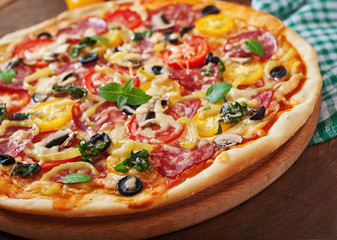 Pizza with salami, tomato, cheese and olives