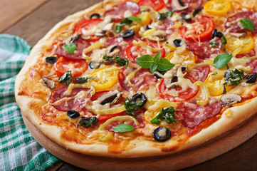 Pizza with salami, tomato, cheese and olives