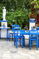 Fototapeta na wymiar Traditional blue greek chairs in a backyard