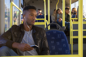 Young man using a smartphone on the bus