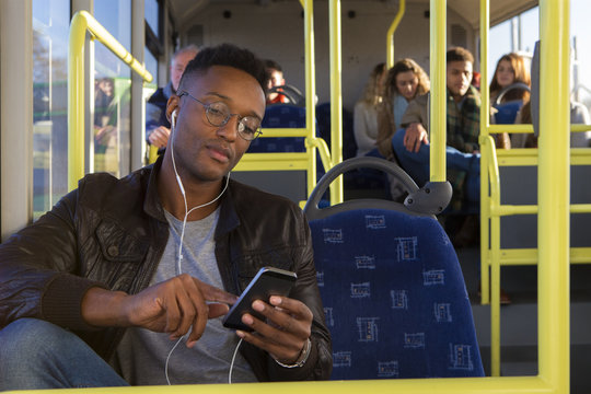 Young man using a smartphone on the bus