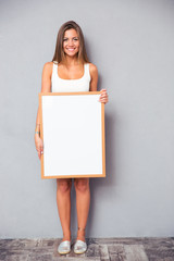 Smiling woman holding blank board
