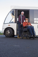 Elderly couple getting off their community bus © dglimages