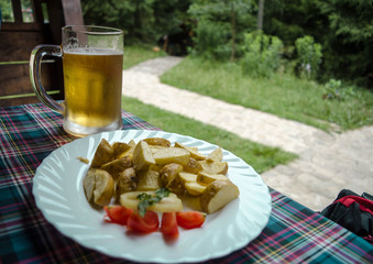 Beer glass and plate of food. Mug of beer on the table. Junk foo