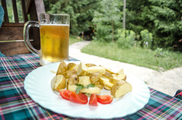 Beer glass and plate of food. Mug of beer on the table. Junk foo