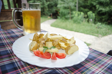 Beer glass and plate of food. Mug of beer on the table. Junk foo